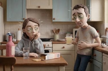 Image of hangover nausea — a man and woman in Aardman claymation style looking queasy together in a morning kitchen, crackers and electrolyte drink on the counter.